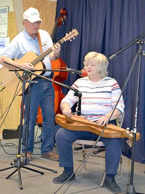 A man and a woman perform with musical instruments