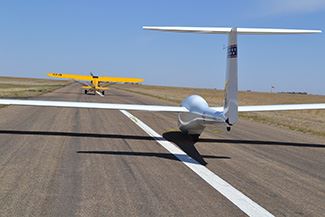A glider takes off on an airport runway