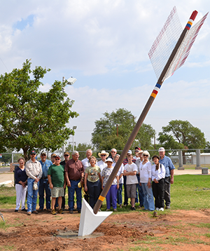 A crowd of people gather at the arrow raising event