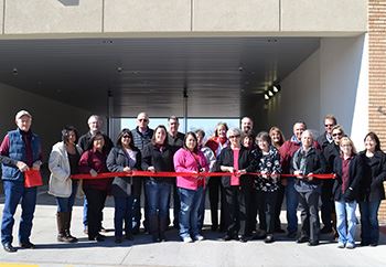 People gather for a ribbon cutting at a local business